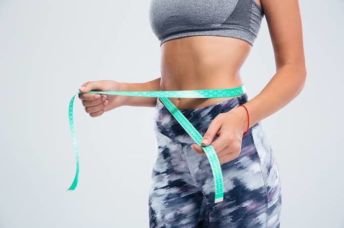 Do high protein diets affect weight management, and body composition? An image of a person holding a measuring tape around their waist would suggest yes.
