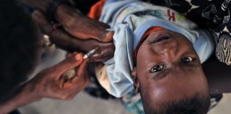 An image of a child getting an early measles vaccination.