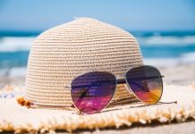 sun hat and sunglasses on sand