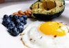 egg, avocado, nuts, and blueberries on a plate