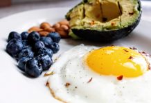 egg, avocado, nuts, and blueberries on a plate