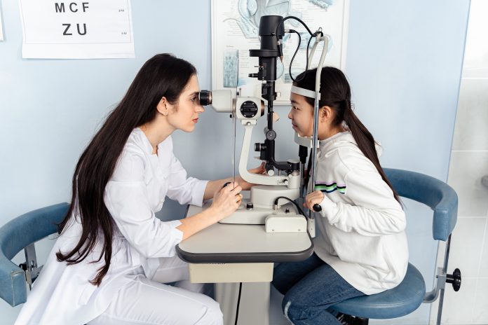 A young girl with an optometrist