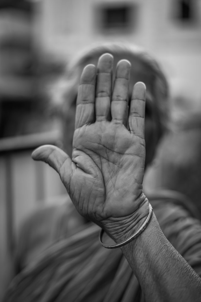 An aging person giving the rejection hand to aging.