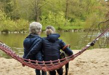 Two women sitting on a hammock sharing stories about menopause symptoms and their menopause treatment options,