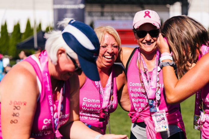 A group of women wearing the breast cancer ribbon to celebrate one woman's survival after overcoming aggressive breast cancer.