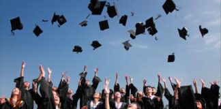 Photo of many teenagers at their graduation, tossing their graduation hats in the air.