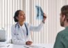 Photo of a black female physician reviewing an imaging test for a patient.