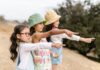 Photograph of a group of girls pointing at the same time to a point.