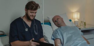 Photo of a doctor attending to a patient in his hospital bed.