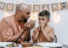 A father sitting at the dinner table talking with his son.