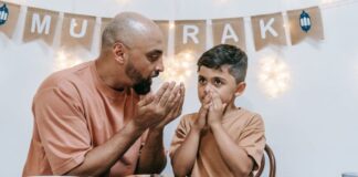 A father sitting at the dinner table talking with his son.