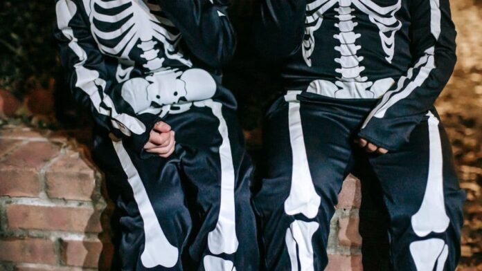 Photo of two teenagers dressed as skeletons.